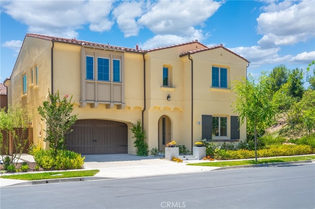 66 Poncho, Irvine, CA 92602 - mediterranean / spanish house featuring stucco siding, driveway, an attached garage, and a tile roof