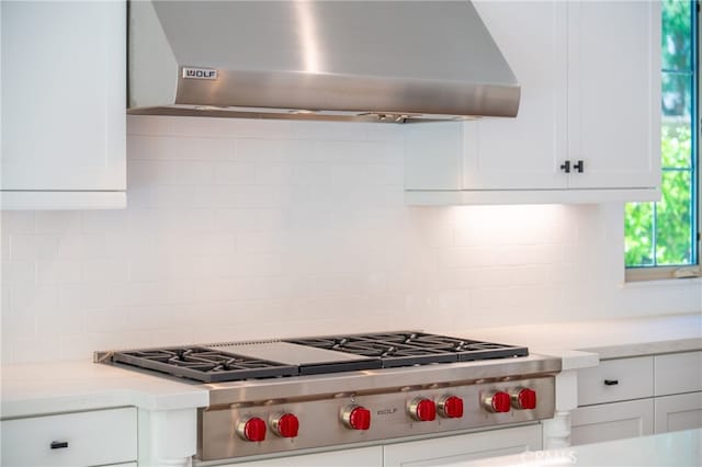 66 Poncho, Irvine, CA 92602 - kitchen with wall chimney exhaust hood, stainless steel gas stovetop, decorative backsplash, white cabinetry, and light stone counters