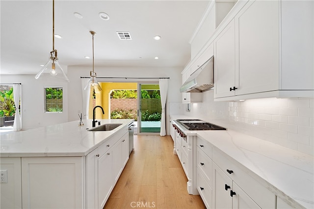 66 Poncho, Irvine, CA 92602 - kitchen with gas stovetop, plenty of natural light, under cabinet range hood, a kitchen island with sink, and recessed lighting