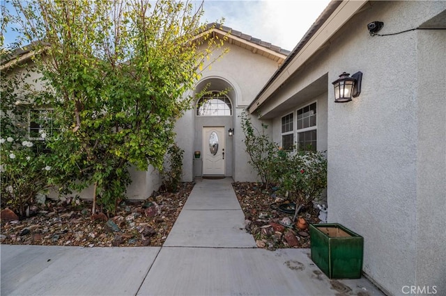 view of exterior entry with a patio