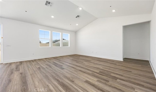 spare room with recessed lighting, wood finished floors, visible vents, baseboards, and vaulted ceiling