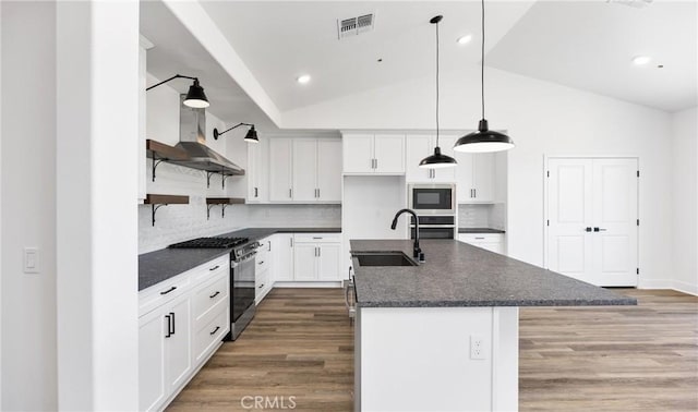 kitchen with white cabinets, visible vents, stainless steel appliances, and an island with sink