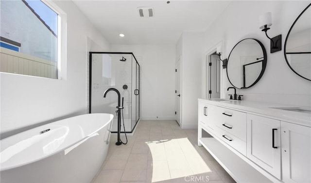 full bathroom with a sink, a freestanding bath, tile patterned floors, double vanity, and a stall shower