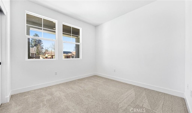 carpeted empty room with baseboards