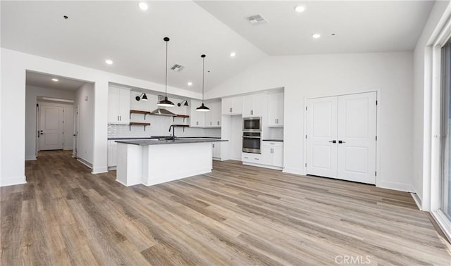 kitchen with open shelves, stainless steel appliances, dark countertops, visible vents, and white cabinets