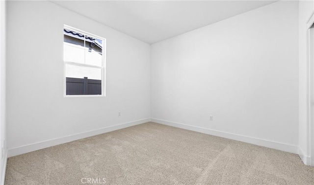 unfurnished room with carpet floors and baseboards