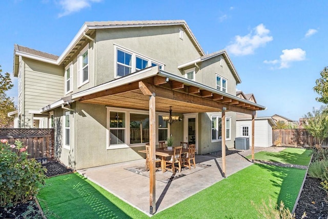 back of property with a yard, central AC, a patio area, and a storage unit