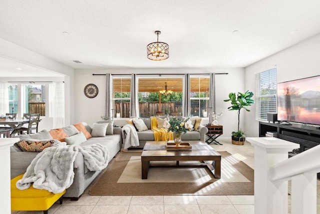 tiled living room with a healthy amount of sunlight and a notable chandelier