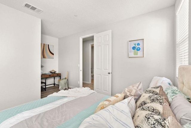 bedroom featuring multiple windows and hardwood / wood-style floors