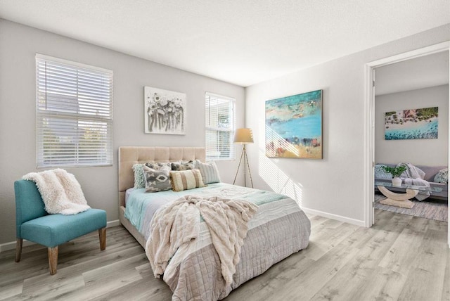 bedroom featuring multiple windows and light wood-type flooring