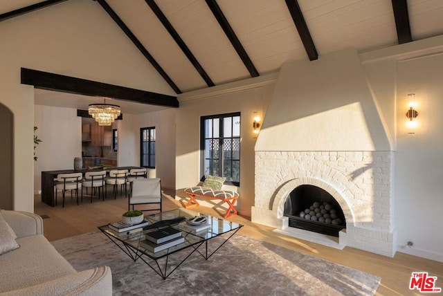 living room with high vaulted ceiling, a fireplace, a notable chandelier, beam ceiling, and wood-type flooring