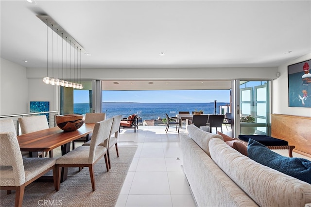 living room with a wealth of natural light, light tile patterned floors, and a water view