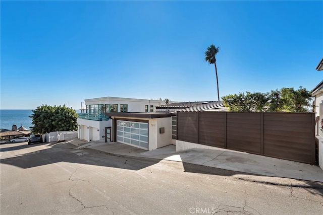 view of front of property with a garage and a water view