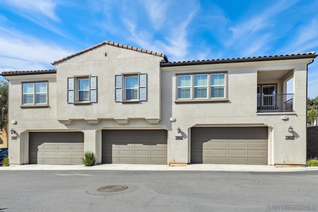 view of front of house featuring a garage and a balcony