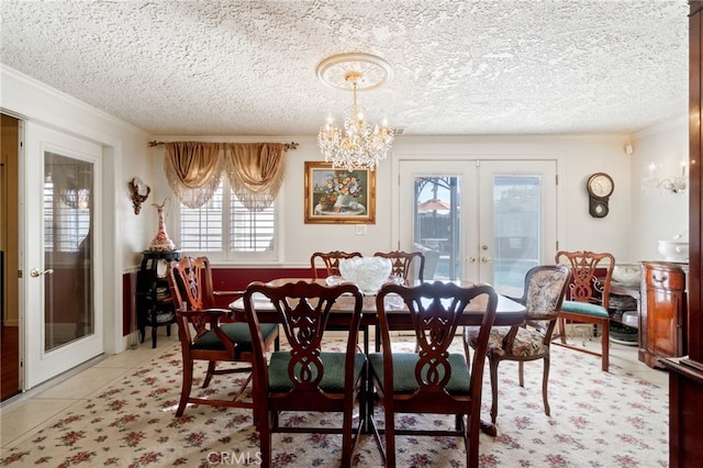 tiled dining space with french doors, a textured ceiling, plenty of natural light, and crown molding