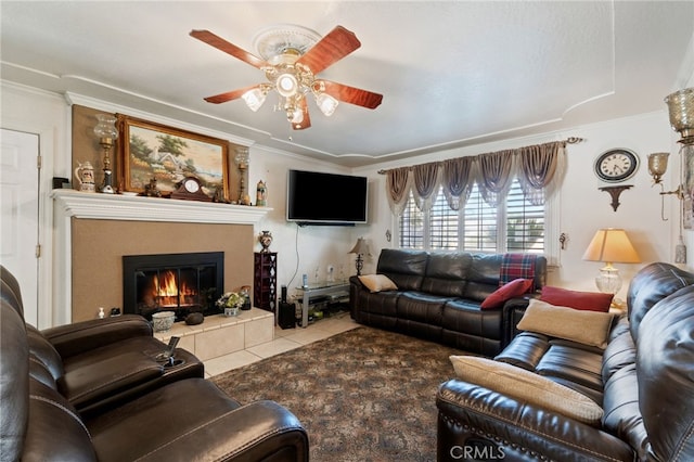 living room with a fireplace, tile patterned floors, ceiling fan, and crown molding