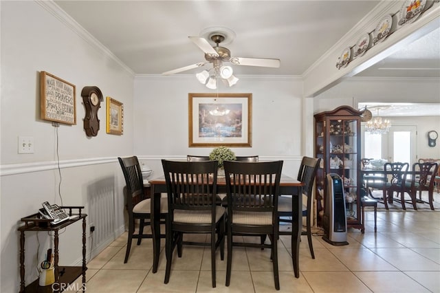 dining area with light tile patterned floors, ceiling fan with notable chandelier, and crown molding