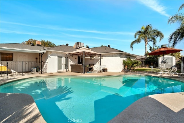 view of swimming pool featuring a patio area and a storage shed