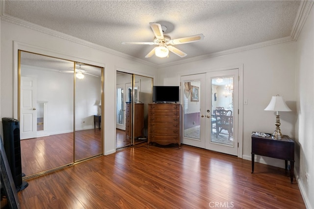 unfurnished bedroom with hardwood / wood-style flooring, multiple closets, a textured ceiling, and french doors