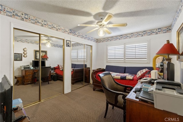 carpeted home office with ceiling fan and a textured ceiling