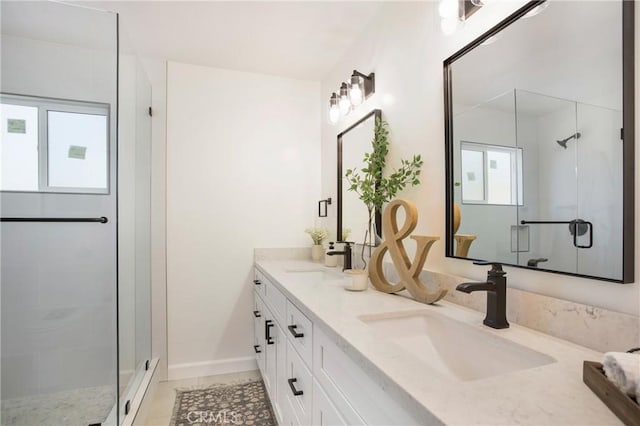 bathroom with a shower with door, vanity, and tile patterned flooring