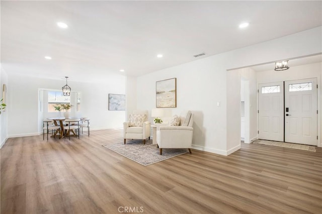 entrance foyer with hardwood / wood-style floors and a notable chandelier