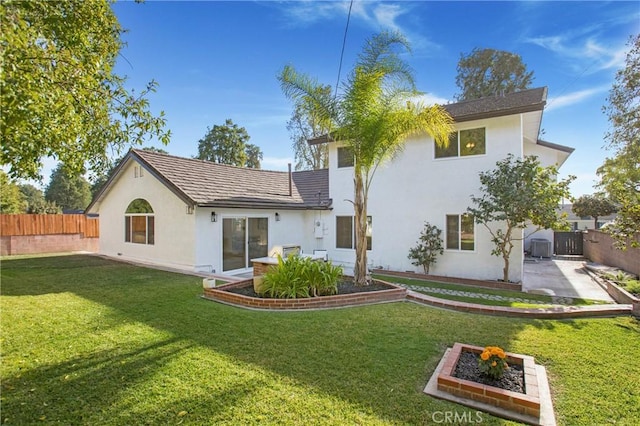 rear view of property featuring a lawn and a patio area