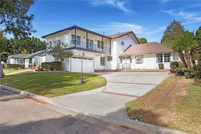 view of front of property featuring a balcony, a front lawn, and a garage