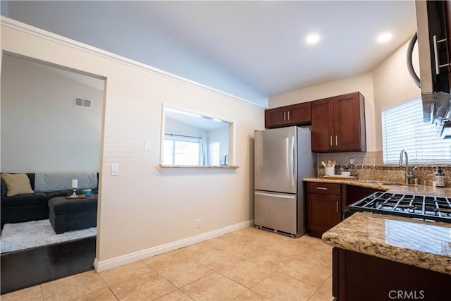 kitchen with decorative backsplash, a wealth of natural light, sink, and stainless steel appliances