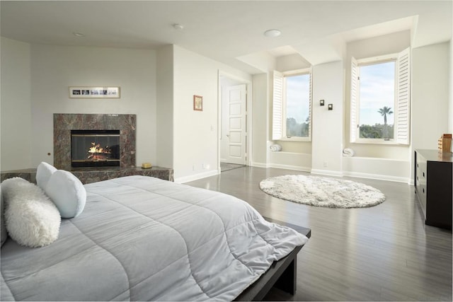 bedroom featuring a premium fireplace and hardwood / wood-style floors