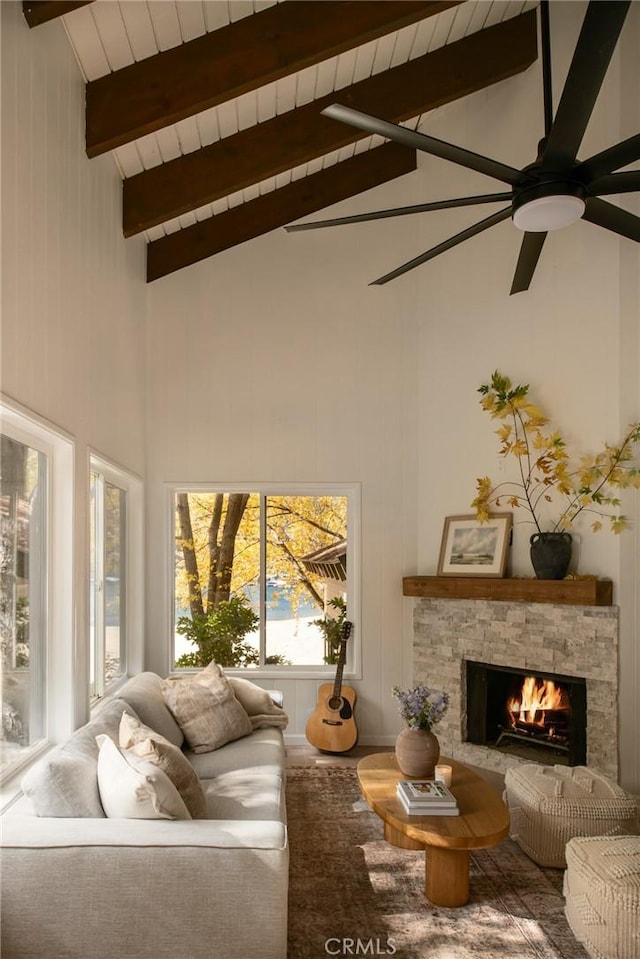 living room featuring high vaulted ceiling, ceiling fan, a fireplace, beamed ceiling, and wood ceiling