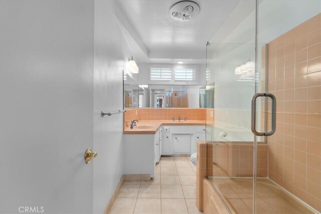 bathroom featuring a shower with shower door, decorative backsplash, tile patterned flooring, vanity, and toilet