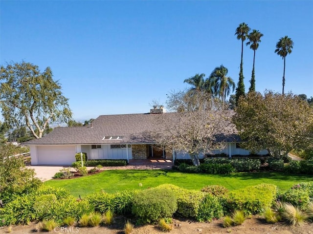 ranch-style house featuring a garage and a front lawn