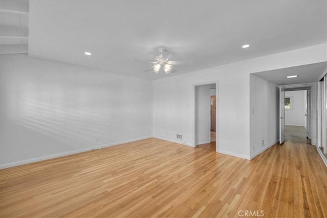 empty room with ceiling fan and light hardwood / wood-style floors