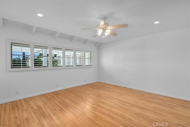 unfurnished room with ceiling fan, plenty of natural light, vaulted ceiling with beams, and light hardwood / wood-style floors