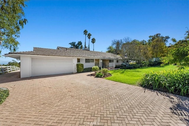 single story home with a garage and a front yard