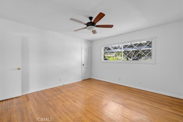 empty room with ceiling fan and light hardwood / wood-style floors