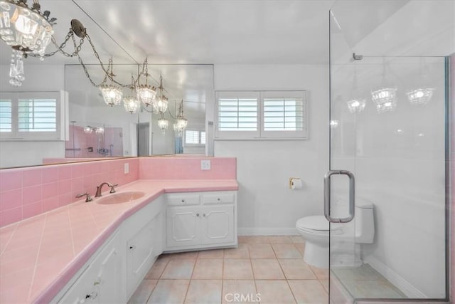 bathroom featuring tasteful backsplash, vanity, an enclosed shower, toilet, and tile patterned floors