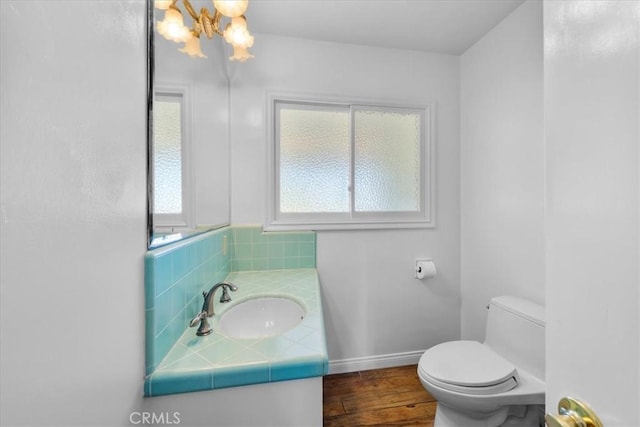 bathroom with vanity, backsplash, toilet, and a chandelier