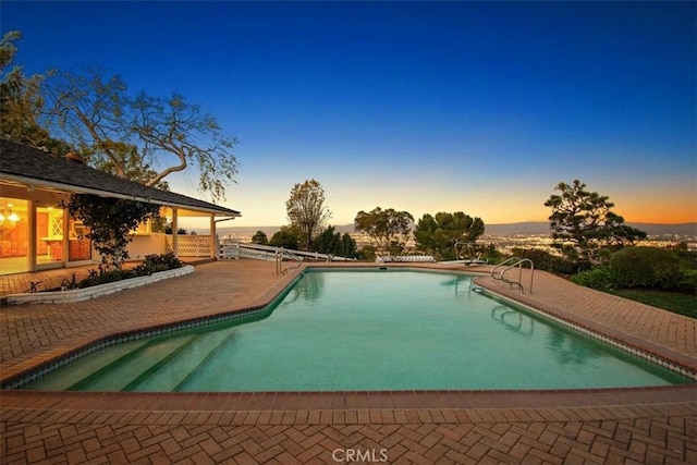 pool at dusk with a patio