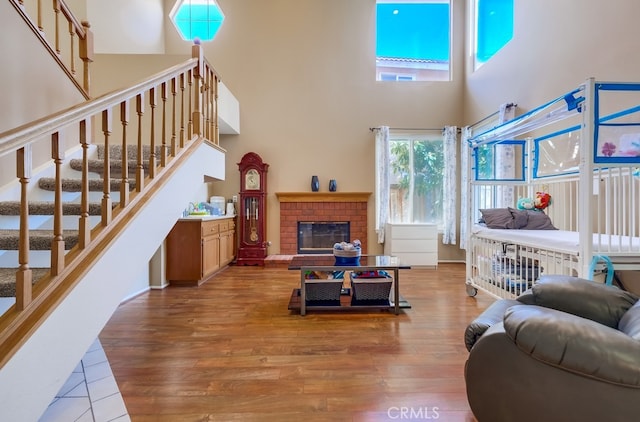 living room featuring hardwood / wood-style flooring, a high ceiling, and a fireplace