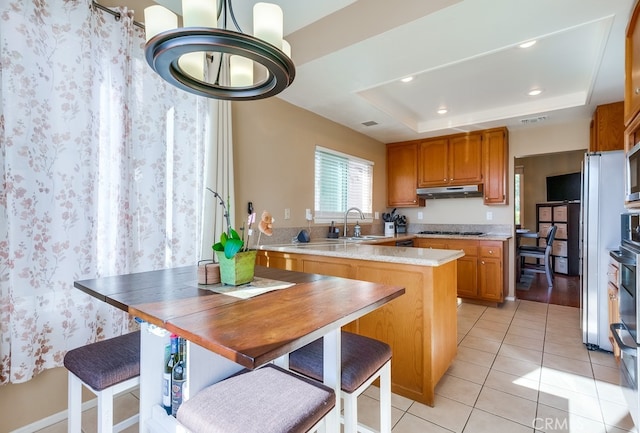 kitchen featuring light tile patterned floors, sink, gas cooktop, and a raised ceiling