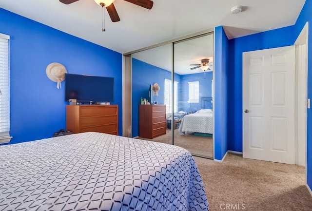 bedroom with ceiling fan, a closet, and light carpet