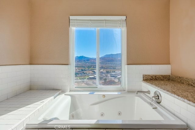 bathroom with a mountain view and tiled bath