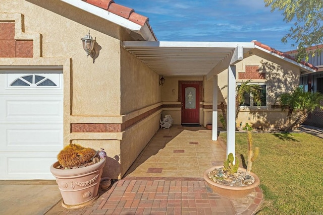 entrance to property featuring a yard and a garage