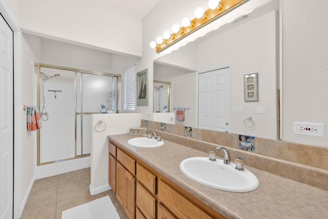 bathroom with tile patterned flooring, vanity, and walk in shower