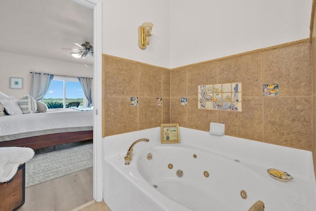 bathroom featuring tiled bath, hardwood / wood-style flooring, and ceiling fan