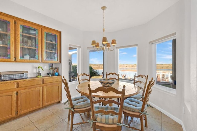 tiled dining area with a water view and an inviting chandelier