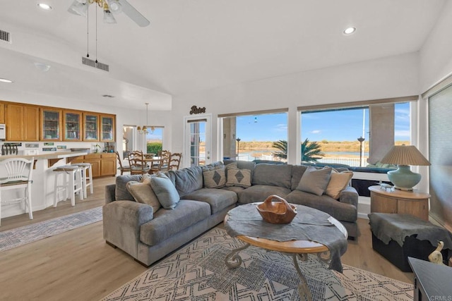 living room featuring high vaulted ceiling, light hardwood / wood-style flooring, and ceiling fan