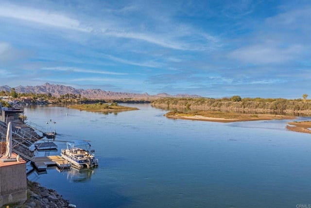 property view of water with a mountain view and a dock